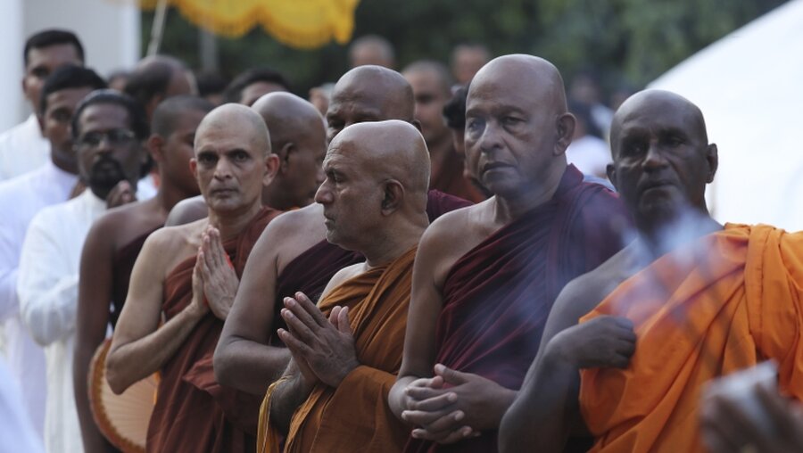 Buddhistische Mönche beten für die Opfer der Anschläge / © Manish Swarup (dpa)