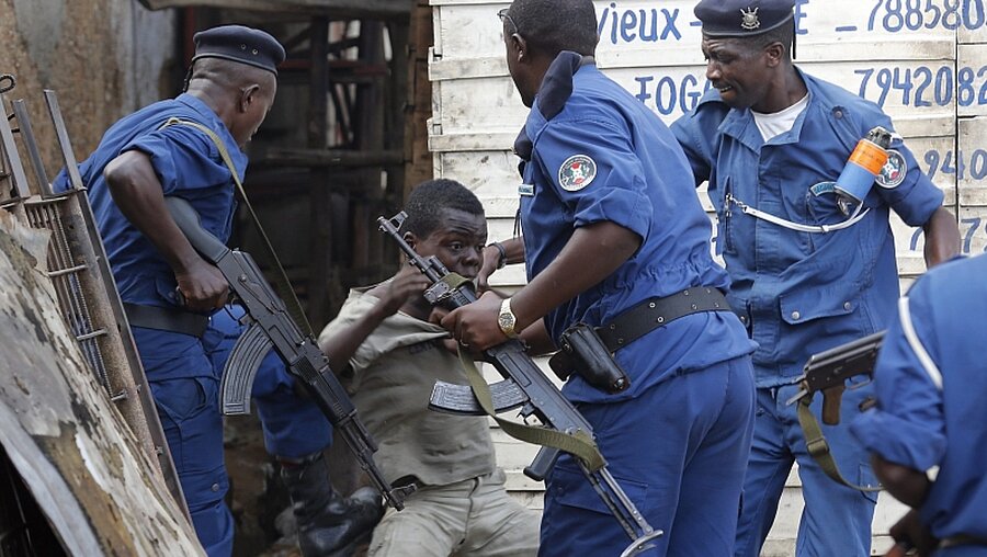 Burundische Polizisten schlagen und treten einen Jungen während einer Demonstration von Regierungsgegnern  / © Dai Kurokawa (dpa)