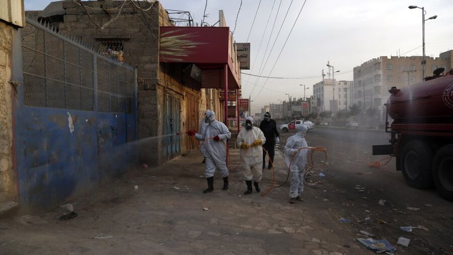 Coronavirus im Jemen: Arbeiter desinfizieren die fassade von Geschäften an einem Straßenrand / © Mohammed Mohammed/XinHua (dpa)