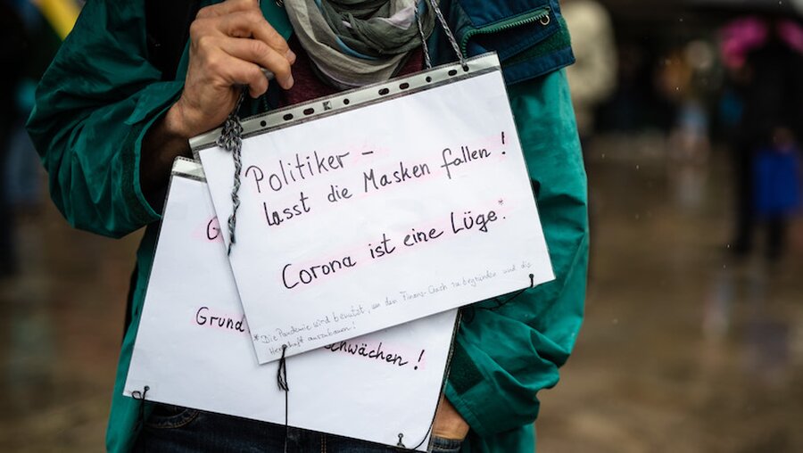 Demonstrant mit Schildern gegen die Corona-Maßnahmen / © Christoph Schmidt (dpa)