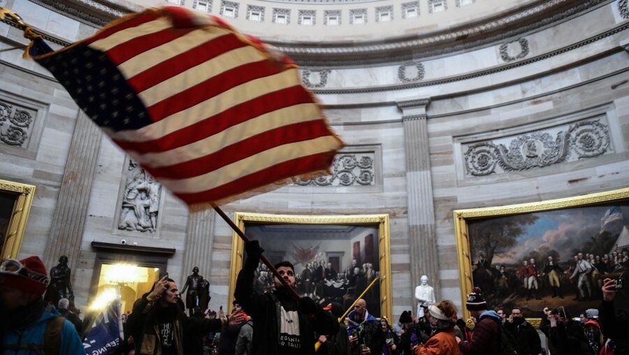 Demonstrant schwenkt die US-Flagge im Inneren des US-Kapitols / © Miguel Juarez Lugo (dpa)
