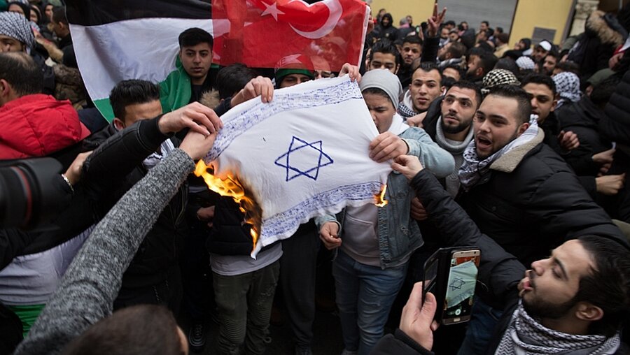Demonstranten verbrennen eine Israel-Fahne / © JVDA e.V. (dpa)