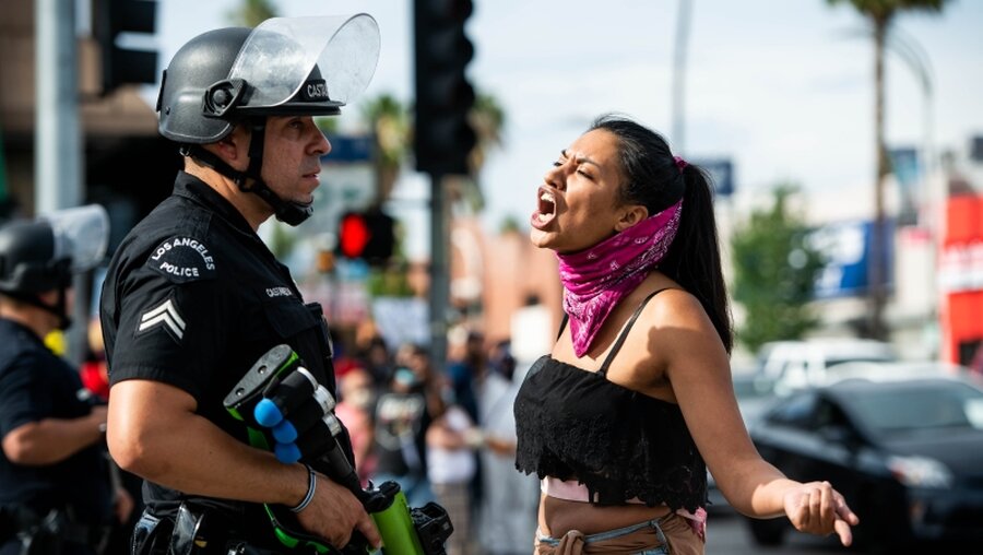 Demonstrantin schreit während einer Kundgebung Polizisten an / © Sarah Reingewirtz (dpa)