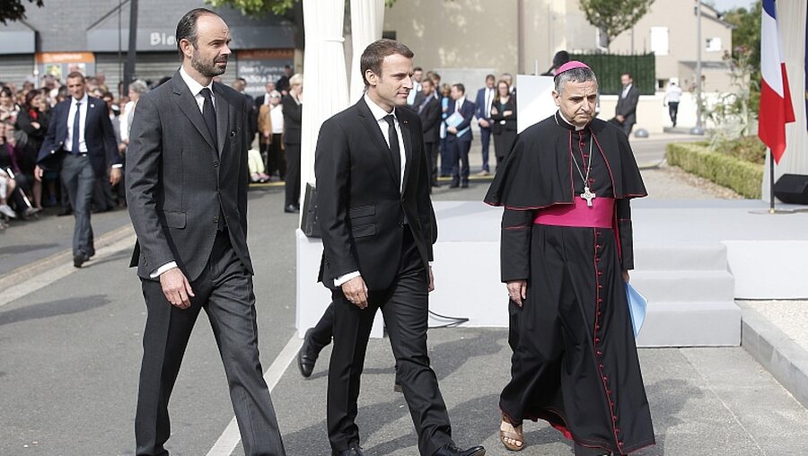 Der französische Premierminister Edouard Philippe (l-r), Frankreichs Präsident Emmanuel Macron und Dominique Lebrun, der Erzbischof von Rouen / © Thibault Camus (dpa)