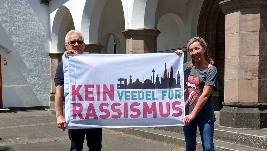 Diakon Dr. Zenon Szelest und Rosa Maria Bianco mit "Kein Veedel Für Rassismus"-Fahne / © N.N. (privat)