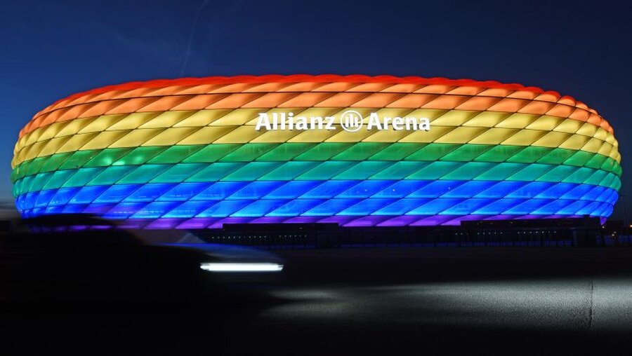 Die Hülle der Allianz Arena leuchtet in Regenbogenfarben / © Tobias Hase (dpa)