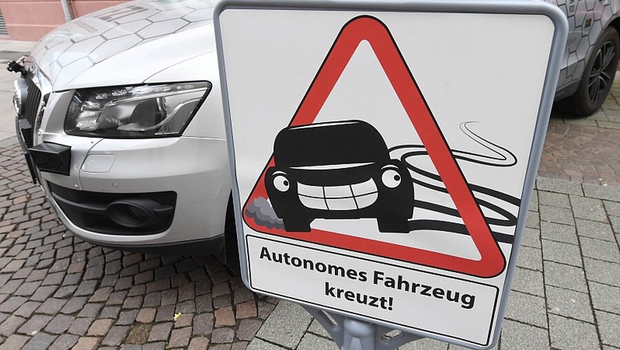 Schild "Autonomes Fahrzeug kreuzt" / © Uli Deck (dpa)