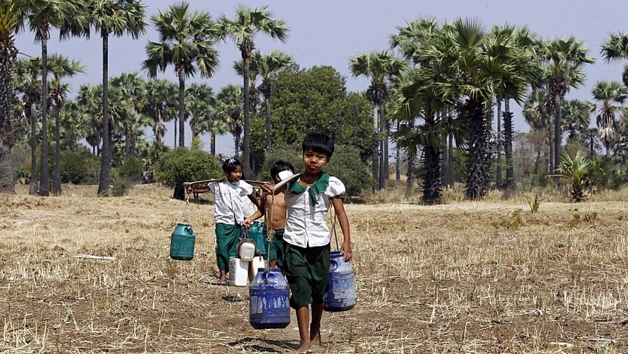 Folgen von Klimawandel und Industrie: Kinder tragen Trinkwasser kilometerweit nach Hause / © Hein Htet (dpa)