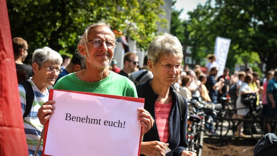 Ein AfD-Demonstrant mit einem Plakat "Benehmt Euch!" / © Harald Oppitz (KNA)