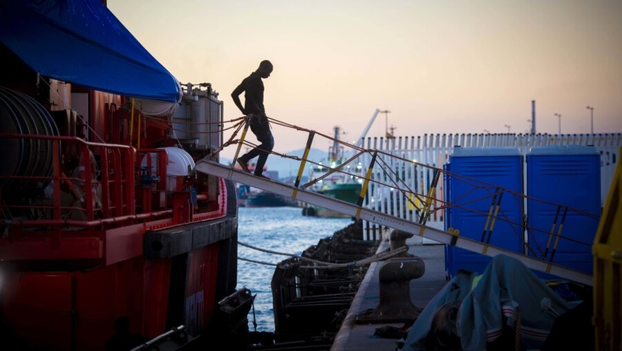 Ein aus Seenot geretteter Migrant geht von Bord eines Schiffs vom spanischen Seerettungsdienst / © Marcos Moreno (dpa)