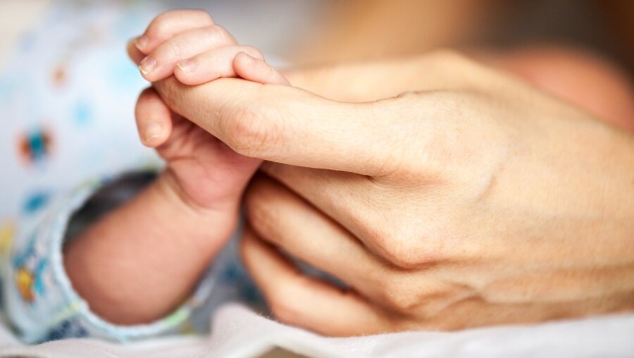 Ein Baby hält den Finger der Mutter fest / © Photobac (shutterstock)