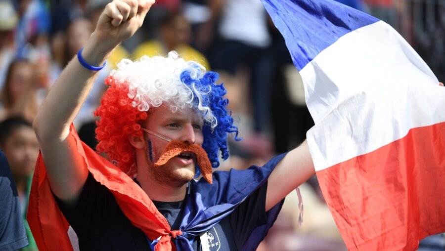 Ein Fan von Frankreich weht mit einer Nationalfahne.  / © Federico Gambarini (dpa)