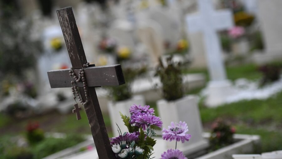 Ein Holzkreuz mit einem Rosenkranz auf einem Grab / © Cristian Gennari/Romano Siciliani (KNA)