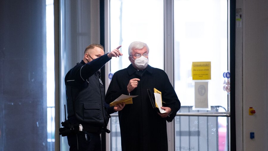 Ein Justizbeamter erklärt Günter Assenmacher, früherer Kirchenrichter des Erzbistums Köln, den Weg zum Gerichtssaal / © Federico Gambarini (dpa)