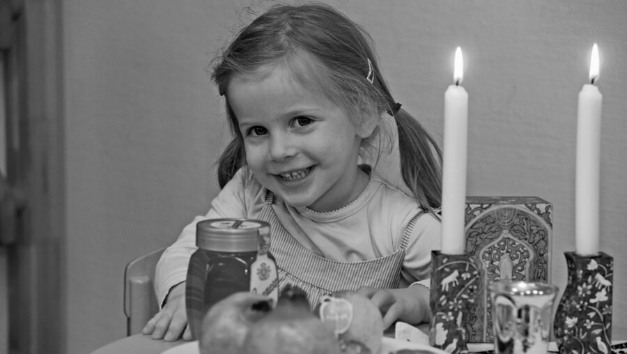 Ein Kind an einem für das jüdische Neujahrsfest (Rosch Haschana) gedeckten Tisch / © Rafael Herlich (privat)