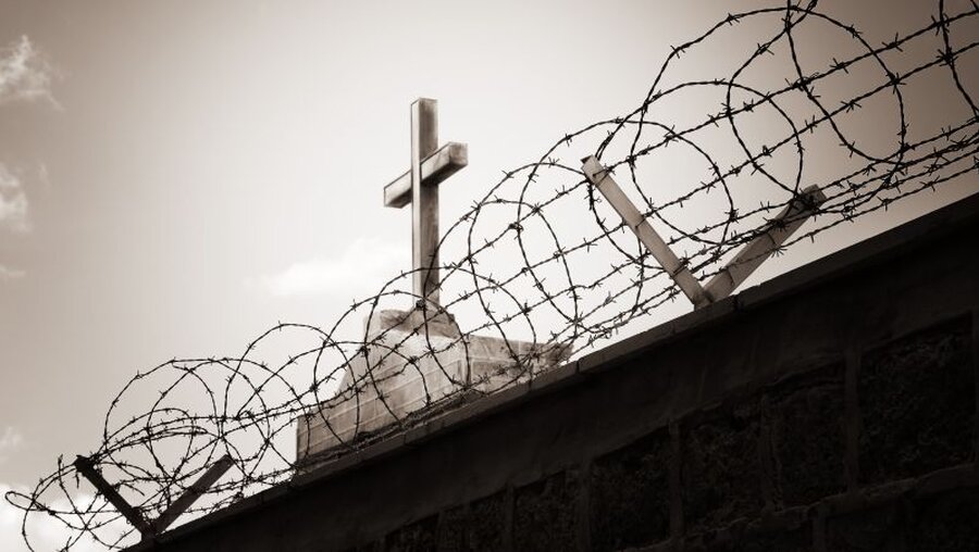 Ein Kreuz hinter Stacheldraht (Symbolbild für Religionsfreiheit) / © Dundanim (shutterstock)