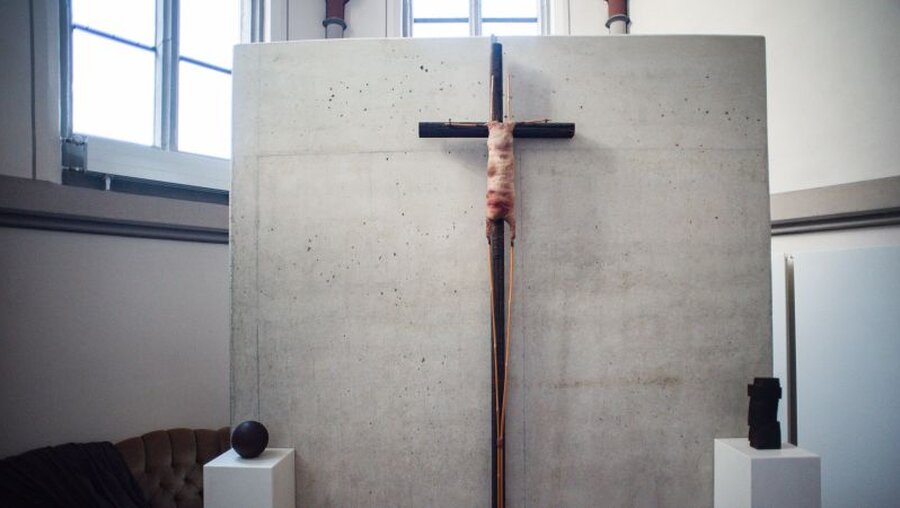 Ein Kreuz mit einem stilisierten Lamm hängt in der Citykirche Mönchengladbach / © Jana Bauch (dpa)