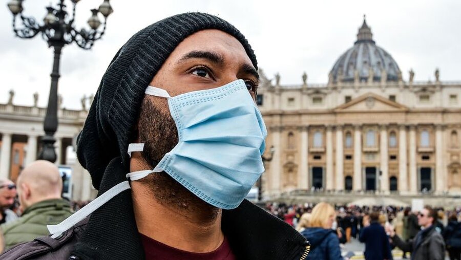 Ein Mann trägt eine Atemschutzmaske während des Angelusgebets / ©  Cristian Gennari (KNA)