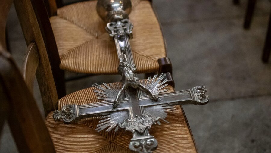 Ein Prozessionskreuz auf einem Stuhl in der Basilika Sainte-Clotilde / © Michel Euler (dpa)