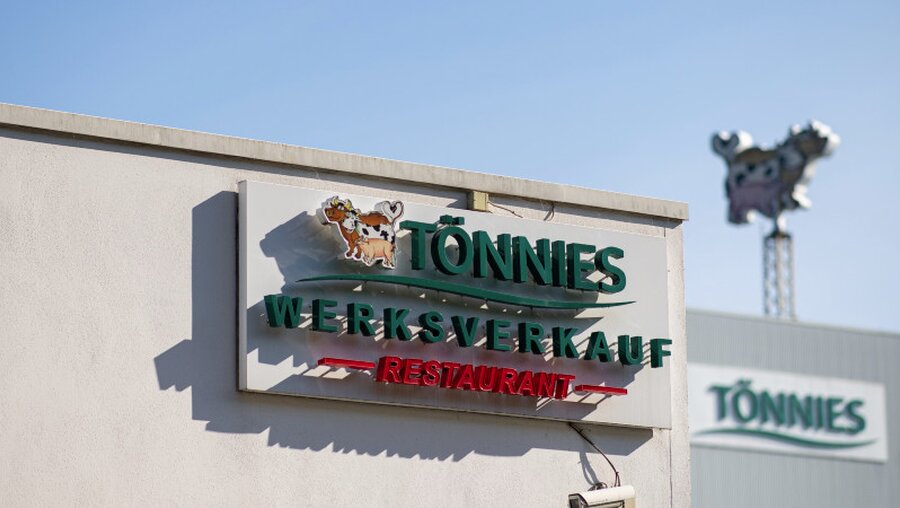 Ein Schild weist auf den Werksverkauf und das Restaurant der Firma Tönnies hin / © Guido Kirchner (dpa)