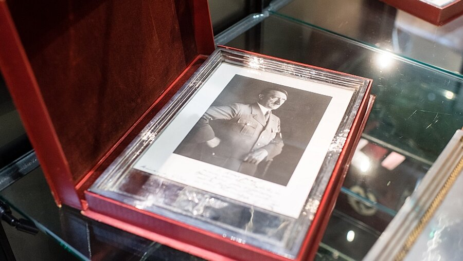 Ein silberner Geschenkrahmen mit einem Porträt Adolf Hitlers / © Matthias Balk (KNA)