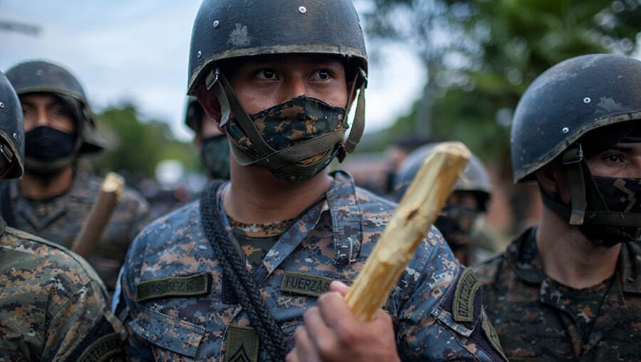 Ein Soldat aus Honduras hält einen Holzknüppel in der Hand / © Sandra Sebastian/AP (dpa)