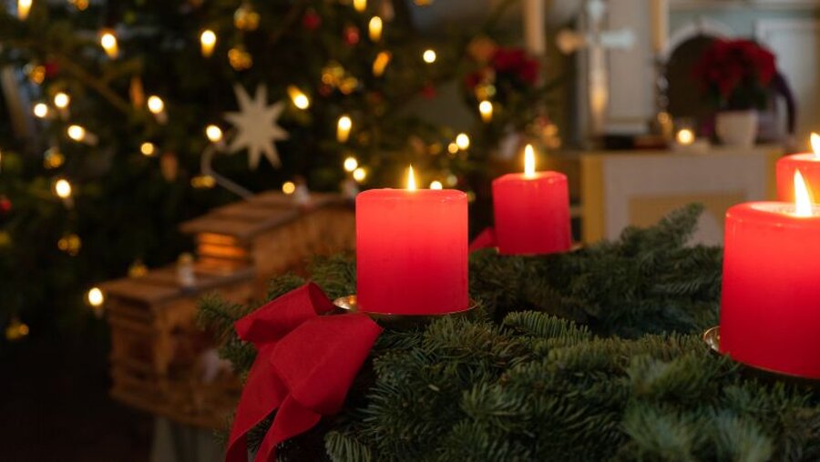 Ein Weihnachtsbaum und ein Adventskranz mit vier brennenden Kerzen in einer Kirche / © Ilay-Meltem Dalkilinc (shutterstock)