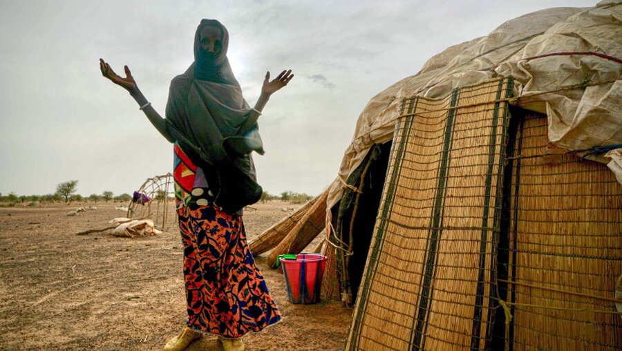 Eine Frau in Burkina Faso steht neben einer Hütte der Vereinten Nationen / © Giles Clarke (dpa)