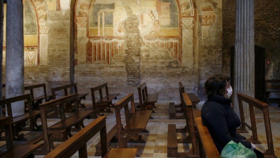 Eine Frau sitzt in einer leeren Kirche in Italien / © Cecilia Fabiano (dpa)