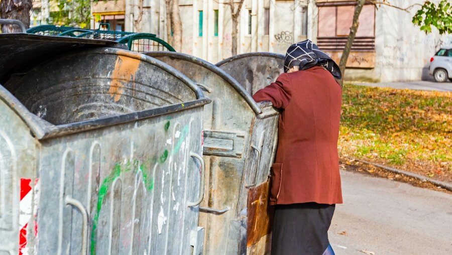 Eine Frau sucht im Abfall nach Essen / © Roman023_photography (shutterstock)