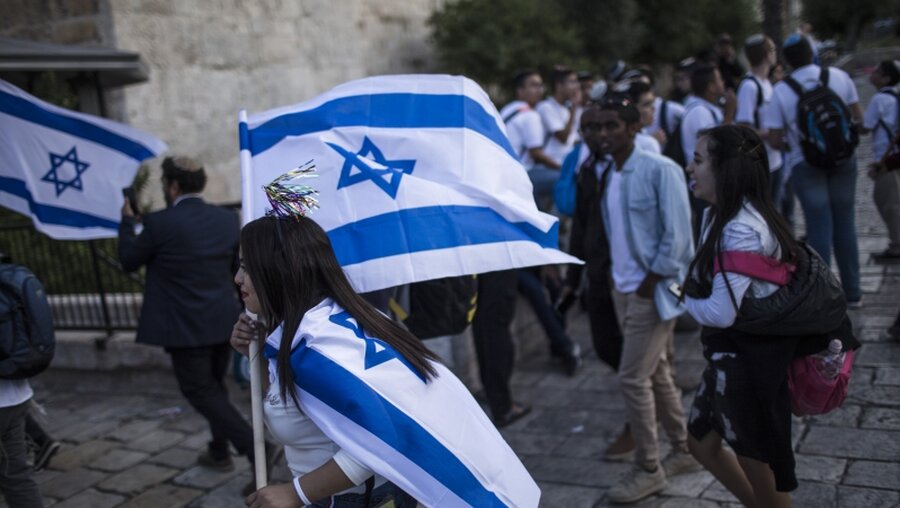 Eine Israelin schwenkt die Flagge ihres Landes / © Ilia Yefimovich (dpa)
