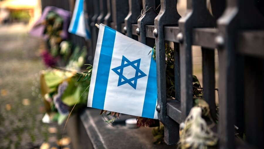 Eine israelische Fahne an einem Gitter vor der Neuen Synagoge in Berlin / © Paul Zinken (dpa)