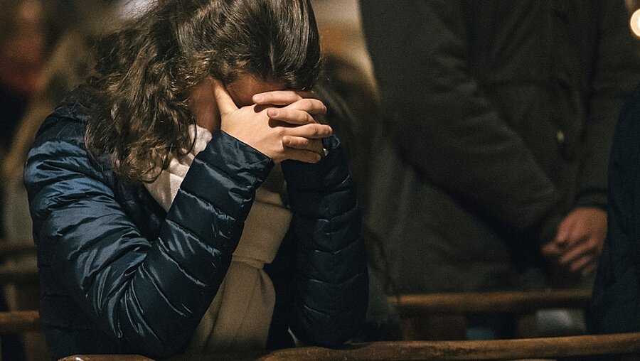 Eine junge Frau betet für die Opfer von Missbrauch durch Kirchenmitglieder / © Fabrice Caterini-Inediz (KNA)