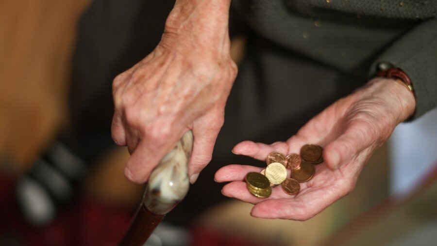 Eine Rentnerin hält ein paar Münzen in der Hand / © Felix Kästle (dpa)