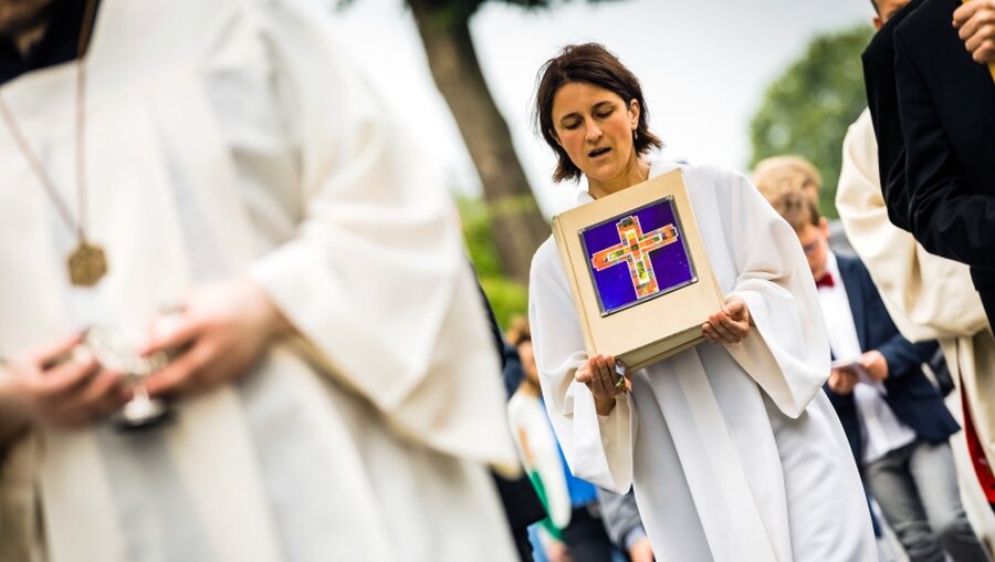 Symbolbild Frau trägt ein Evangeliar bei einer Prozession / © Lars Berg (KNA)