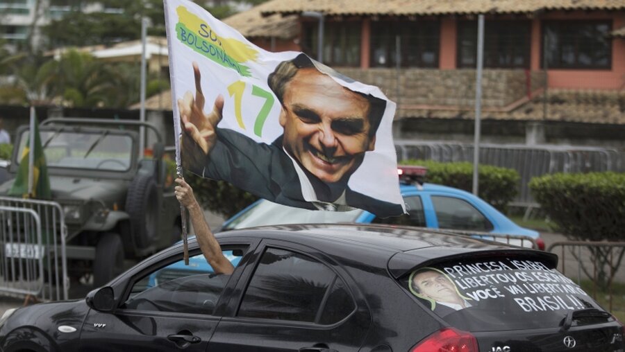 Fahne, die ein Bild von Bolsonaro zeigt / © Leo Correa (dpa)