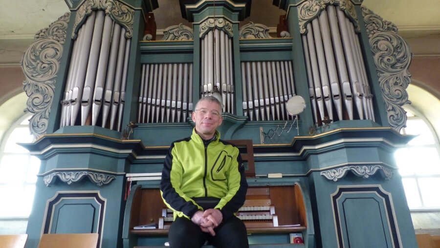 Fahrradkantor Martin Schulze sitzt an einer Orgel / © Martin Schulze  (epd)