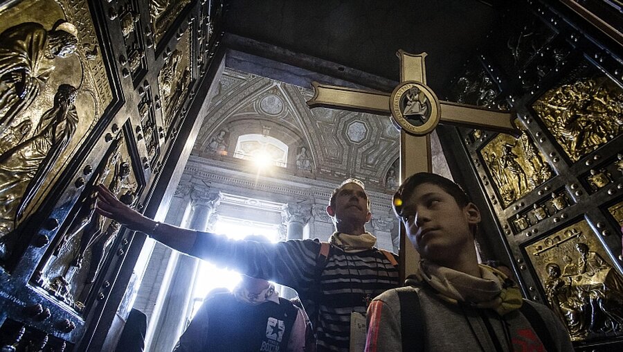 Jugendliche durchschreiten die Heilige Pforte im Petersdom / © EPA/Angelo Carconi (dpa)