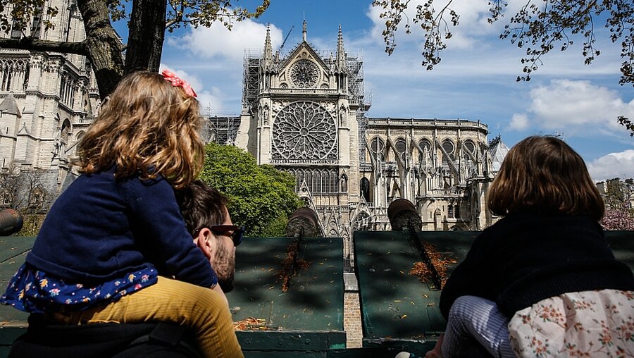 Familie schaut auf die beschädigte Kathedrale Notre-Dame / © Paul Haring/CNS photo (KNA)