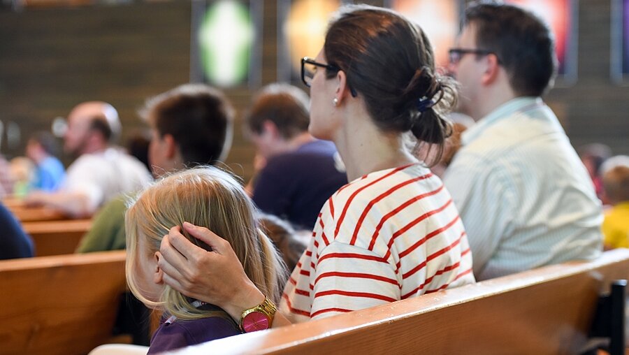 Eine Familie sitzt während des Deutschen Evangelischen Kirchentags am 4.6.15 in Stuttgart in einem Gottesdienst (KNA)
