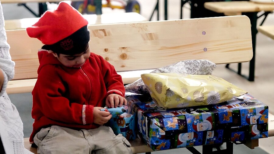 Flüchtlingskind mit Weihnachtsgeschenk / © Peter Steffen (dpa)