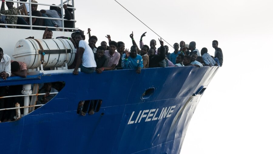 Flüchtlinge stehen am Bug des Rettungsschiffes Lifeline / © Hermine Poschmann (dpa)