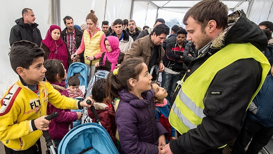 Flüchtlinge warten auf die Essensausgabe / © Boris Roessler (dpa)