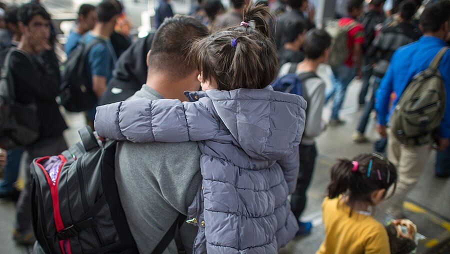 Flüchtling mit Kind auf dem Arm / © Matthias Balk (dpa)