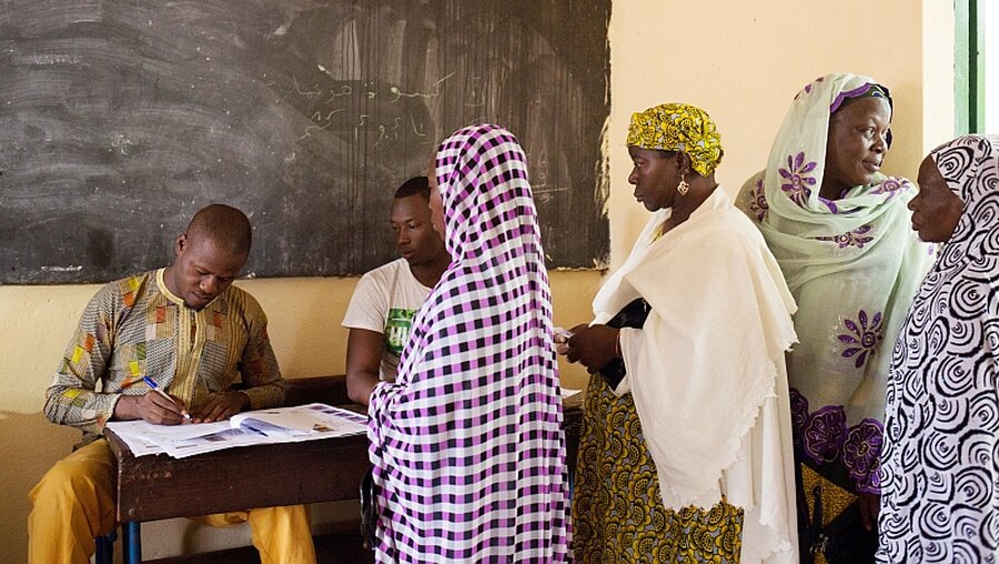 Frauen warten vor Abgabe ihrer Stimme in einem Wahllokal im Krisenstaat Mali / © Annie Risemberg (KNA)