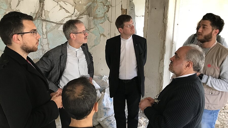 Freiburger Erzbischof Stephan Burger und Peter Neher besuchen ein zerstörtes Haus.  / © N.N. (CI)
