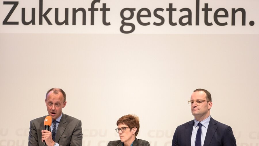 Friedrich Merz, Annegret Kramp-Karrenbauer und Jens Spahn auf der Regionalkonferenz in Lübeck / © Axel Heimken (dpa)