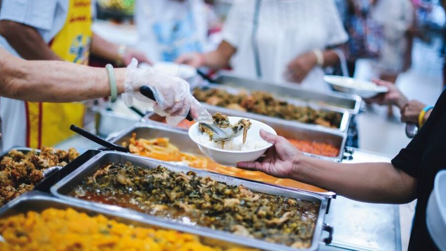 Helfer teilen Essen an Bedürftige aus / © addkm (shutterstock)