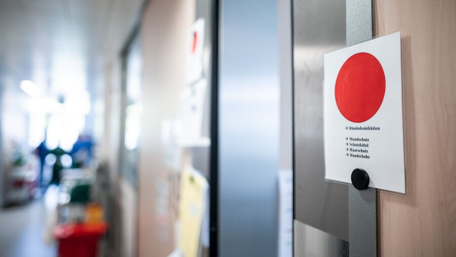 Hinweisschilder mit einem roten Punkt vor den Zimmern auf der Corona-Intensivstation / © Fabian Strauch (dpa)