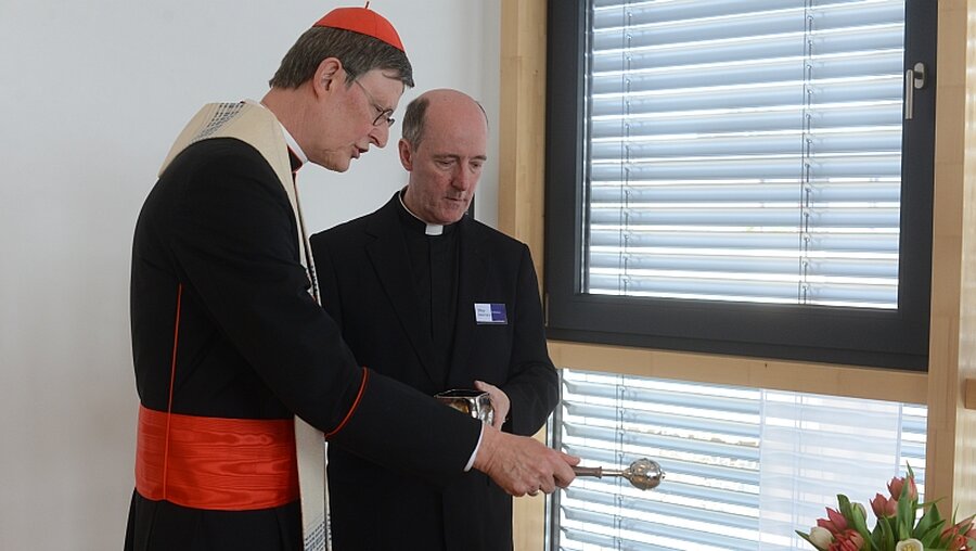  Im Beisein von Dechant Assmann segnet Kardinal Woelki die Kreuze der neuen Einrichtungsräume. / © Beatrice Tomasetti (DR)